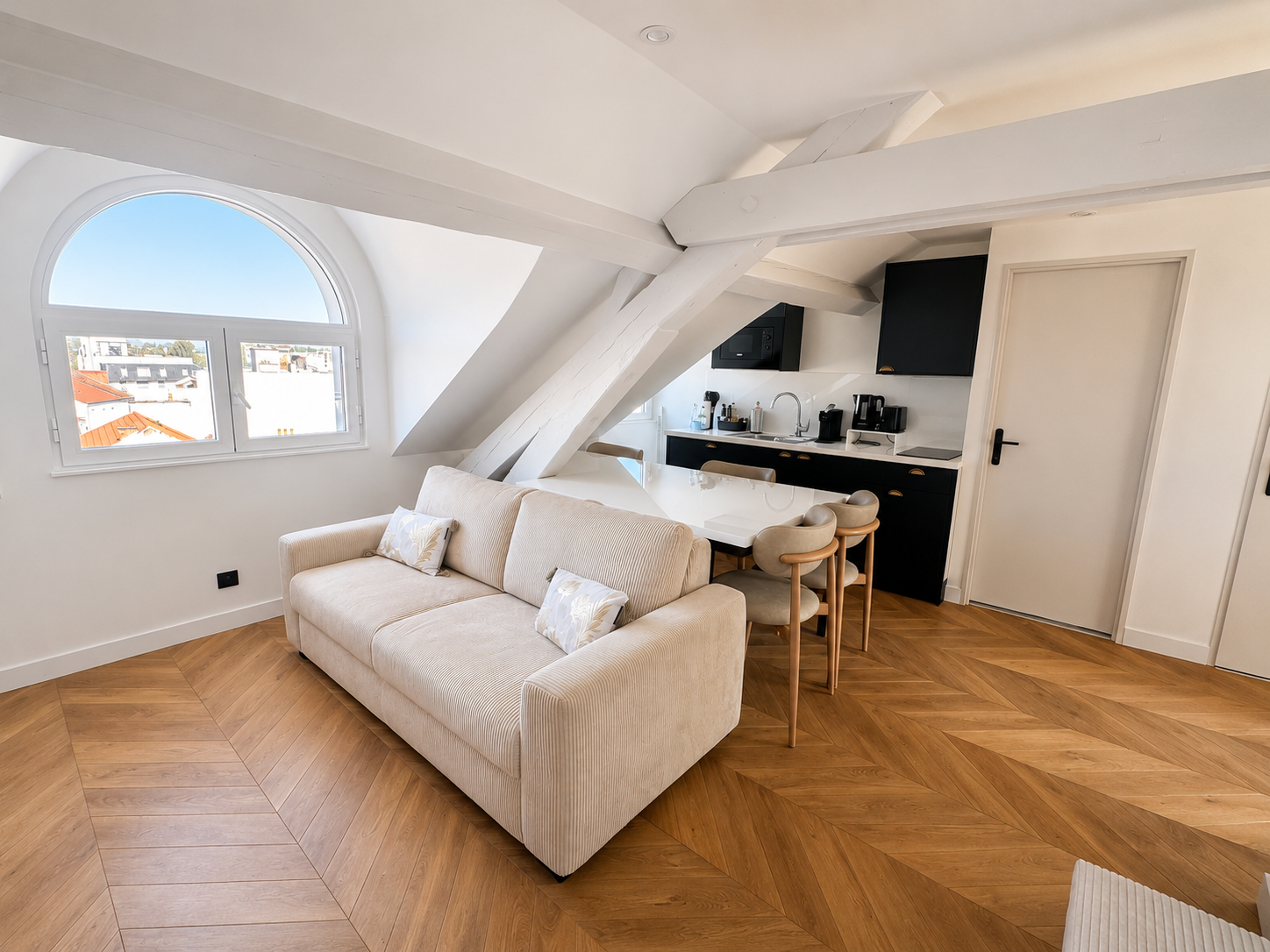 Espace de vie mansardé, poutres apparentes et parquet chevrons