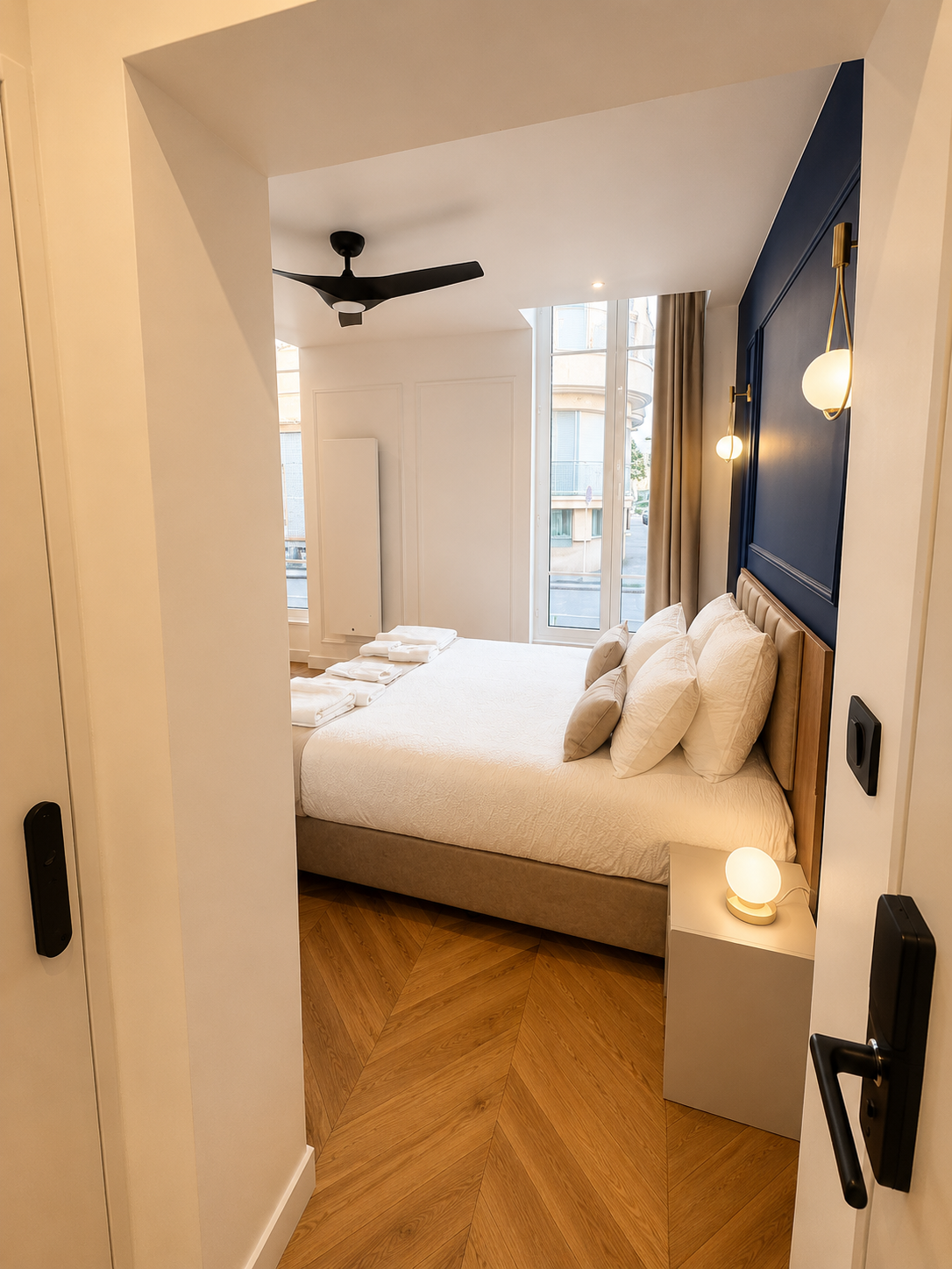 Lit double et appliques laiton, mur bleu saphir