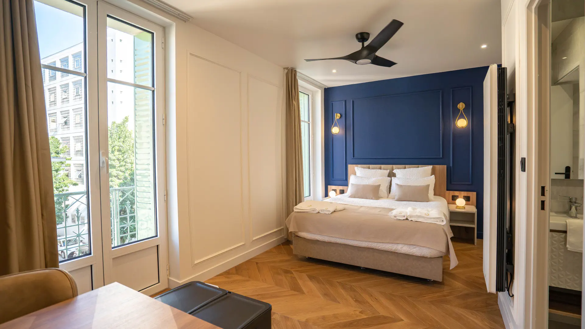 Appart' Deluxe avec Balcon : lit Queen size et porte-fenêtre ouverte sur le balcon