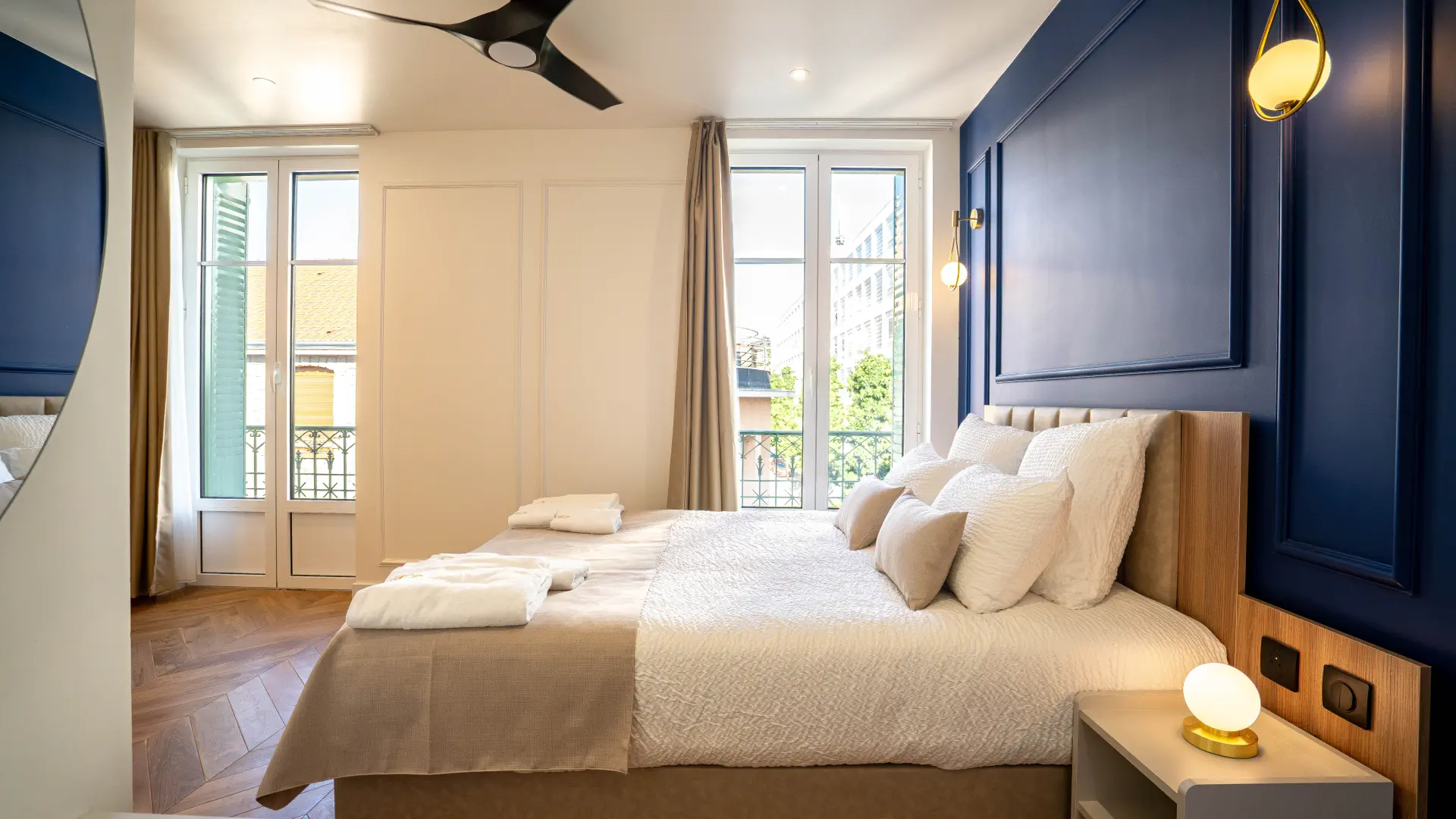 Chambre lumineuse et mur bleu saphir de l'Appart' Deluxe avec Balcon