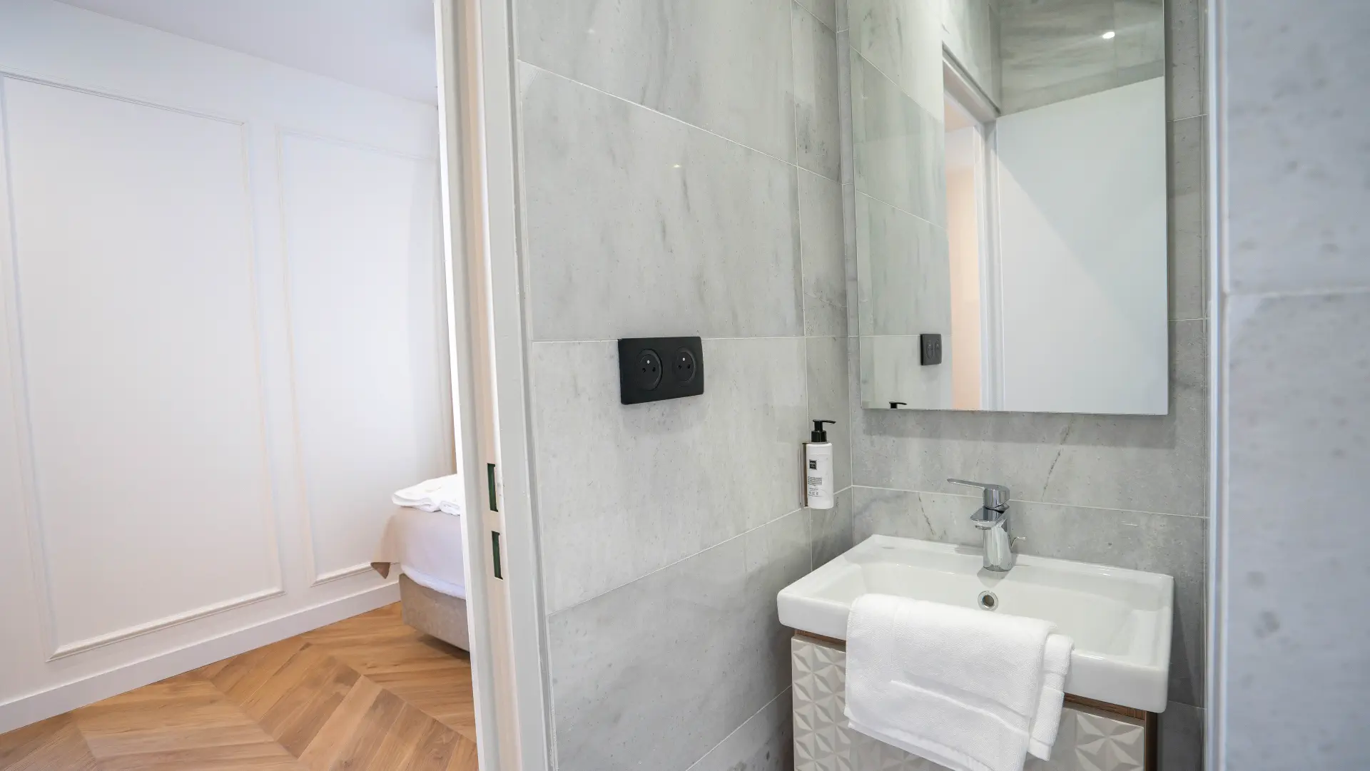Salle d'eau en marbre et parquet chevrons, Appart' Deluxe avec Balcon