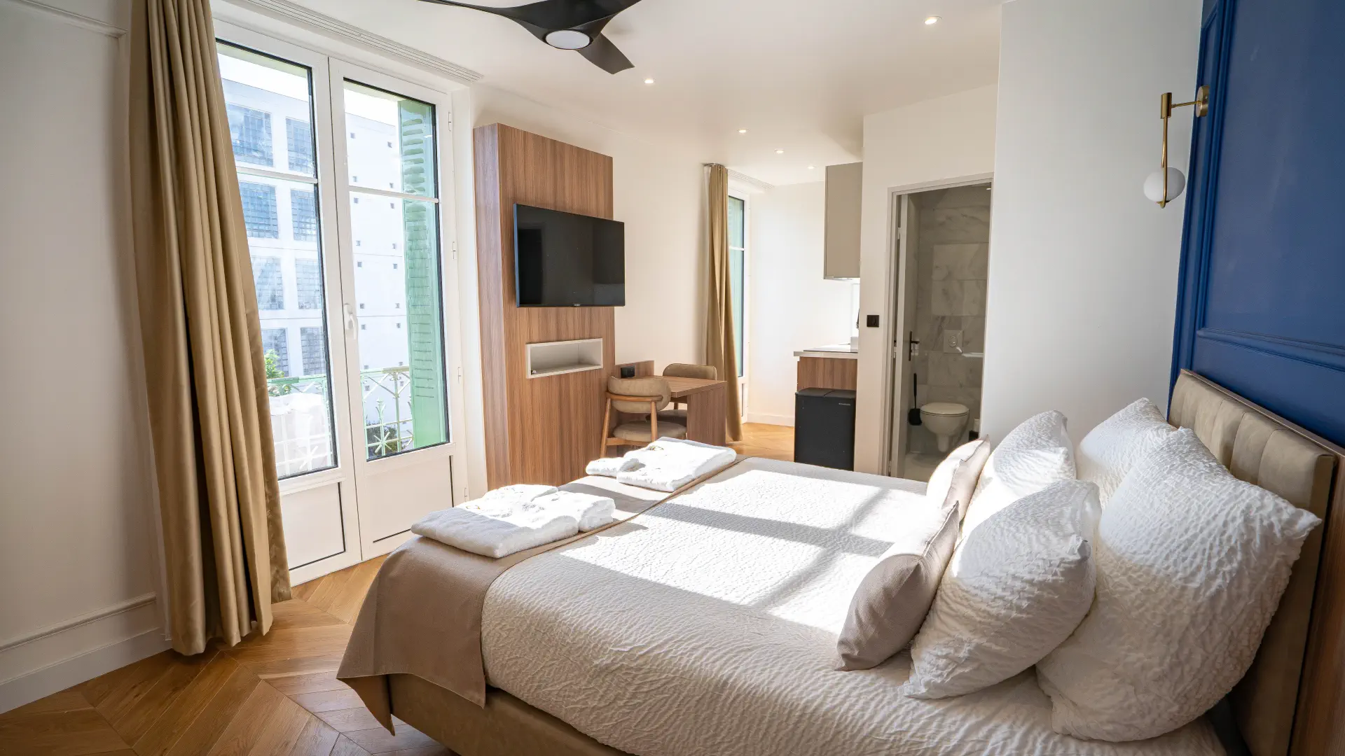 Lit Queen size baigné de soleil, Appart' Deluxe avec Balcon