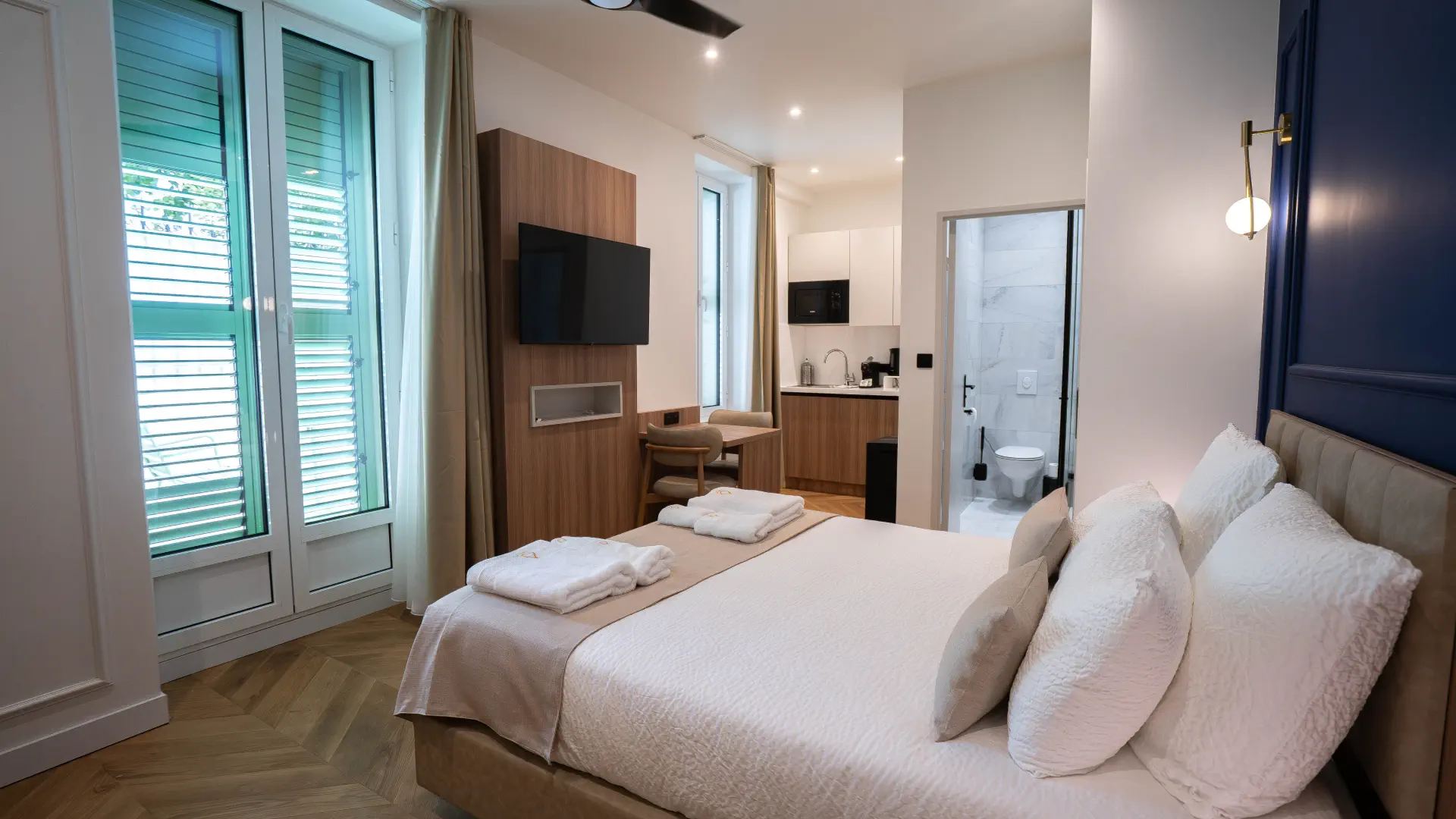 Appart' Deluxe avec Terrasse : lit Queen size et porte-fenêtre sur la terrasse