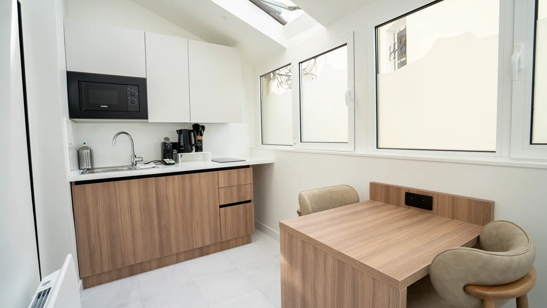 Véranda sous verrière avec cuisine et table, Appart' Deluxe avec Véranda