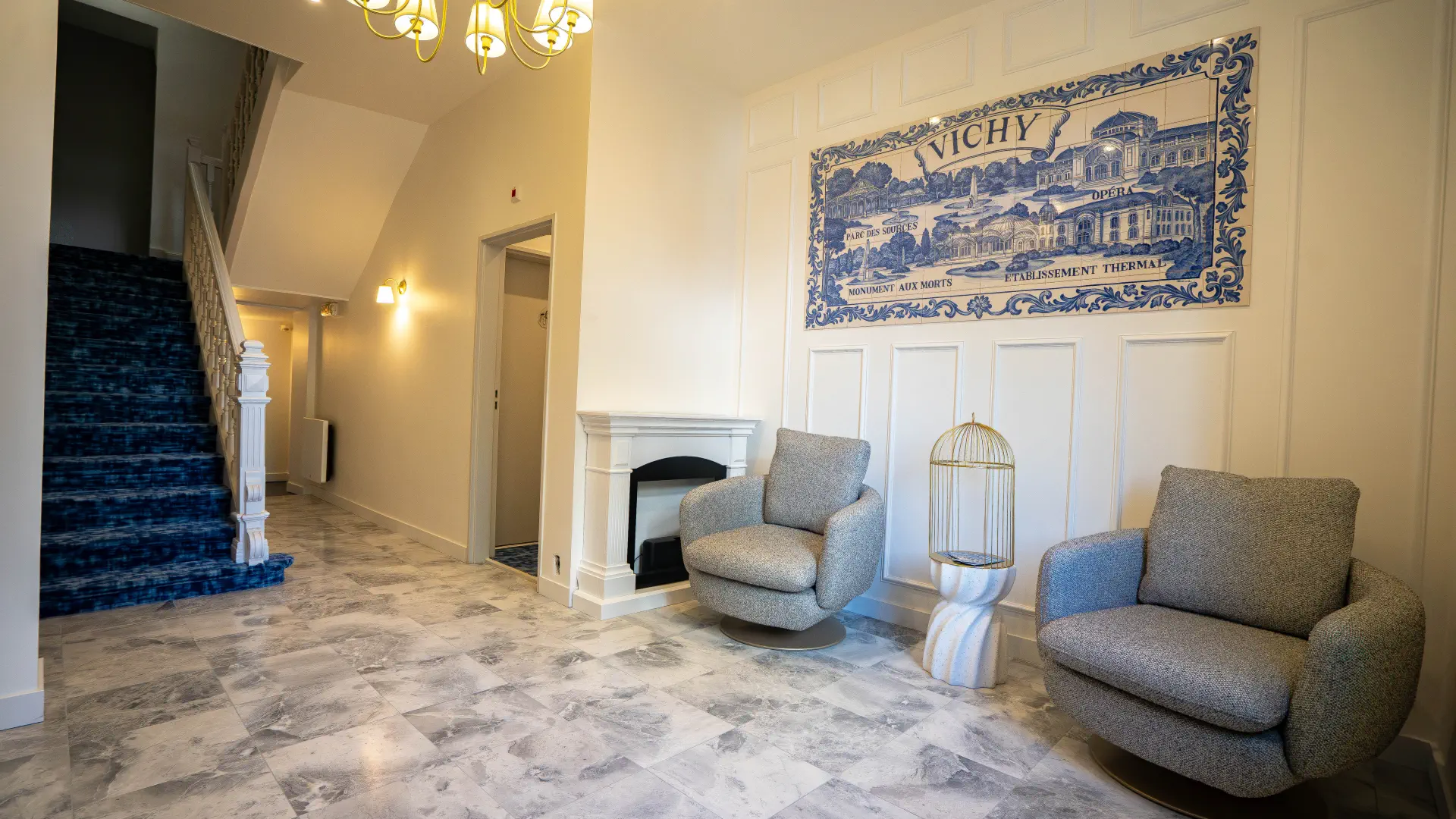Hall d'entrée de l'appart'hôtel à Vichy : marbre, azulejos et cheminée